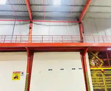 Fixed fire curtain installed in warehouse roof structure